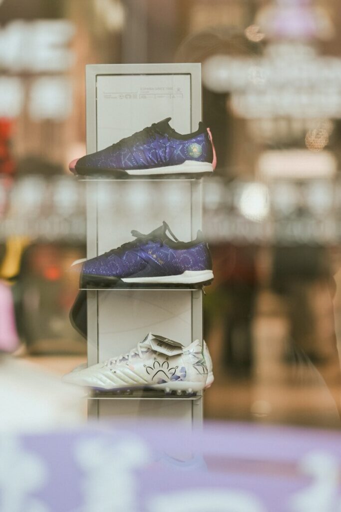Three pairs of athletic shoes displayed on shelves.